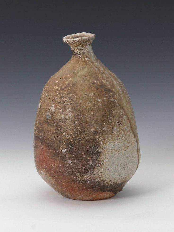 a brown and white vase sitting on top of a table