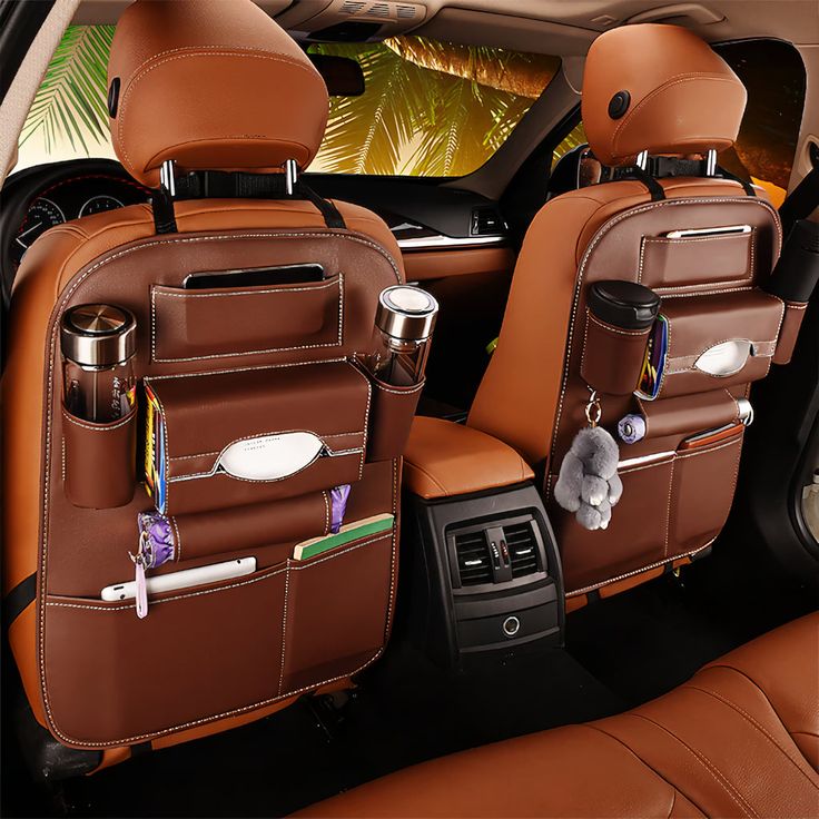 the interior of a car with two brown leather seats and one has an animal on it