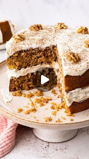 a large piece of carrot cake with white frosting and walnuts on the top