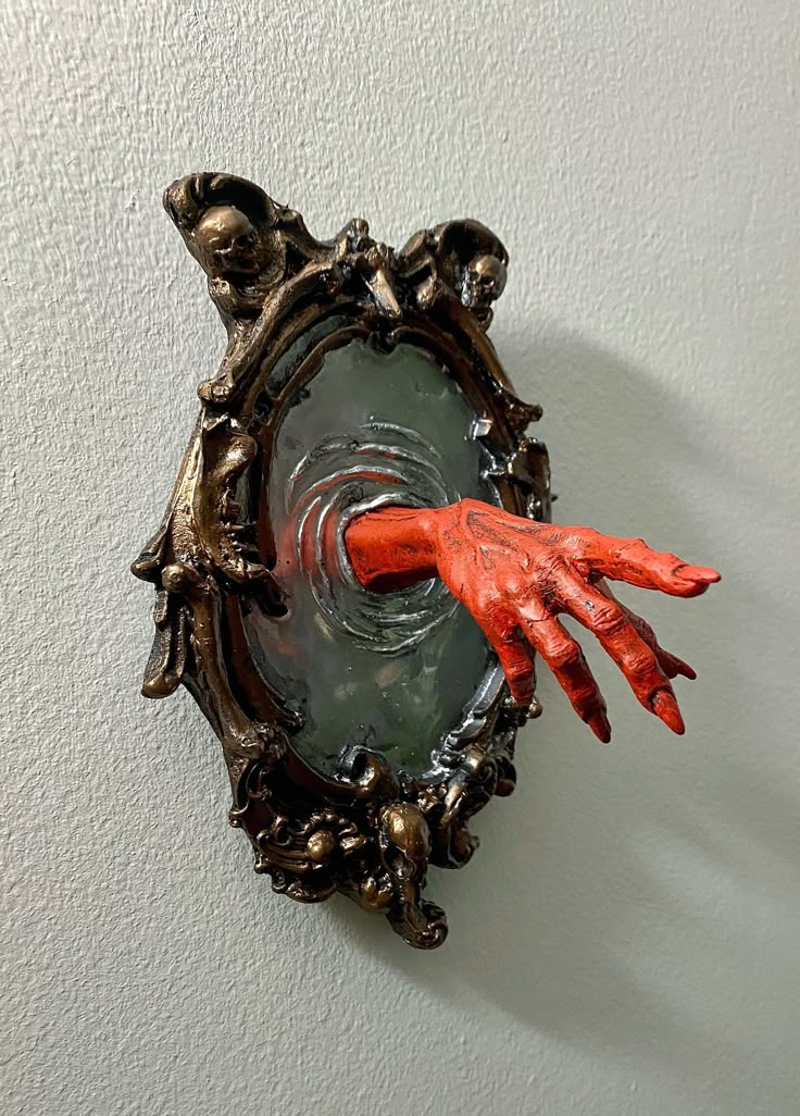 an orange hand sticking out of a mirror on the wall with it's reflection