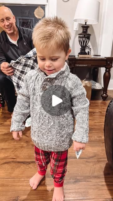 a little boy standing on top of a wooden floor