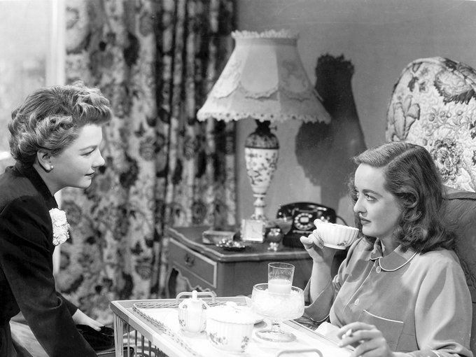 two women sitting at a table drinking tea