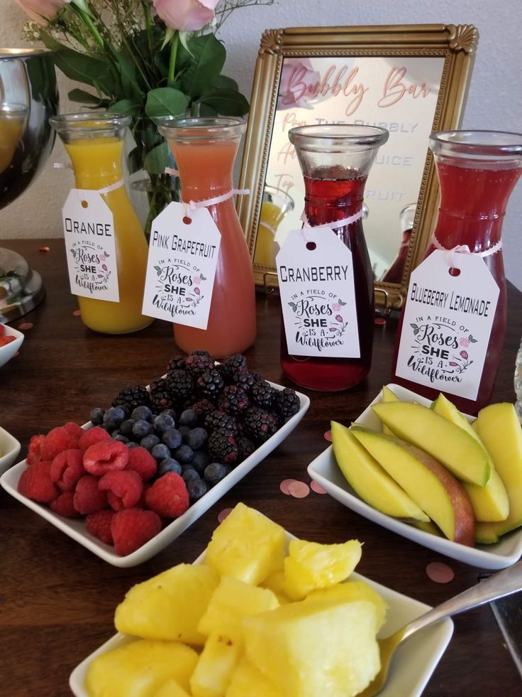 there are many different types of fruit on the table with some tags in front of them