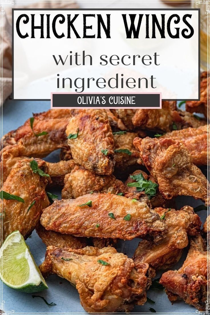 chicken wings on a plate with lime wedges and cilantro in the background