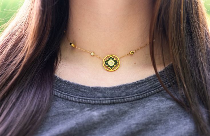 This gold evil eye necklace is the perfect blend of beauty and symbolism. Featuring a round shape with unique detailing and a CZ center with gold accents, this pendant is eye-catching and unique. The pendant hangs from a CZ station necklace, and the bezel CZ come in two different sizes, adding texture and interest to the design. The necklace is water-resistant, making it a great everyday piece. Wear it alone or layer it with other necklaces for a trendy look. The evil eye is a powerful symbol of Gold Jeweled Round Pendant Jewelry, Adjustable Gold Jeweled Necklaces, Spiritual Yellow Gold Necklace With Evil Eye, Spiritual Yellow Gold Evil Eye Necklace, Evil Eye Amulet Pendant Necklace, Evil Eye Amulet Pendant Charm Necklace, Gold-plated Evil Eye Amulet Necklace, Evil Eye Necklace Gold, Crescent Necklace