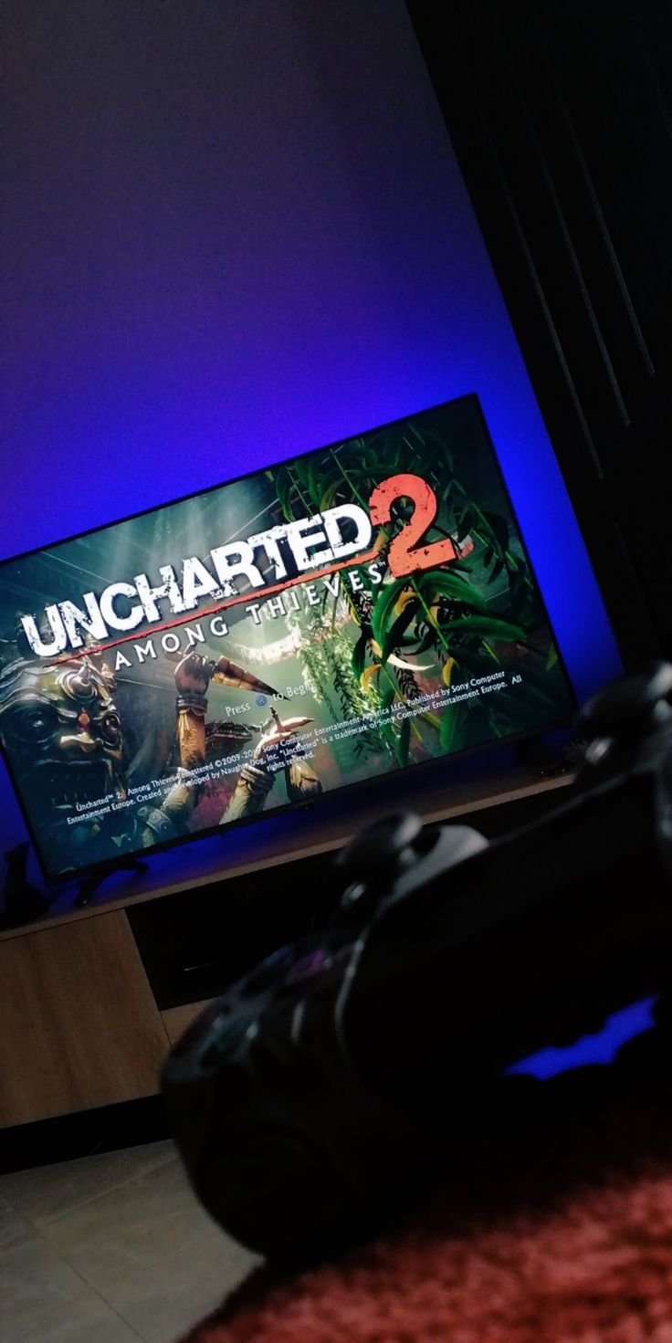 there is a video game called uncharted 2 on the tv screen in the living room