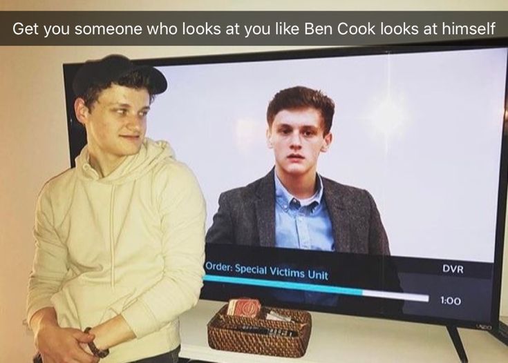 a man standing in front of a flat screen tv next to a basket with food on it