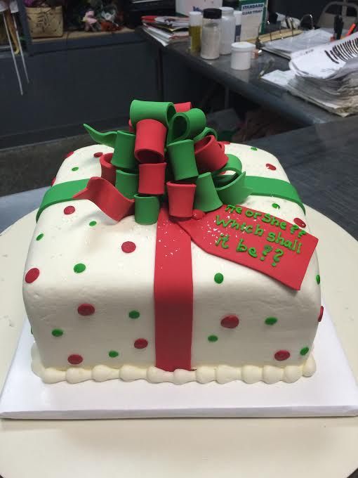 a white cake with green and red decorations on it's side sitting on a table