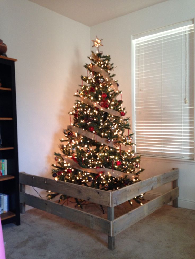 a small christmas tree in a wooden crate with lights on it's top and bottom