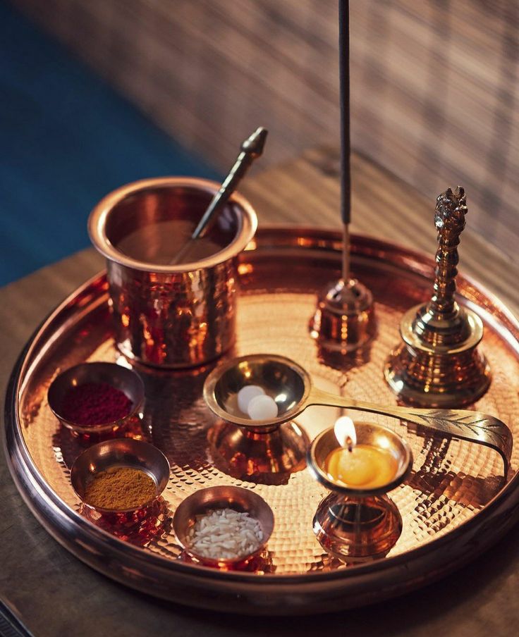 a metal tray with candles and spoons on it