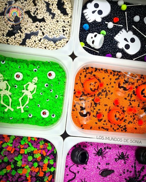 four plastic trays filled with halloween themed rice krispy treats and sprinkles