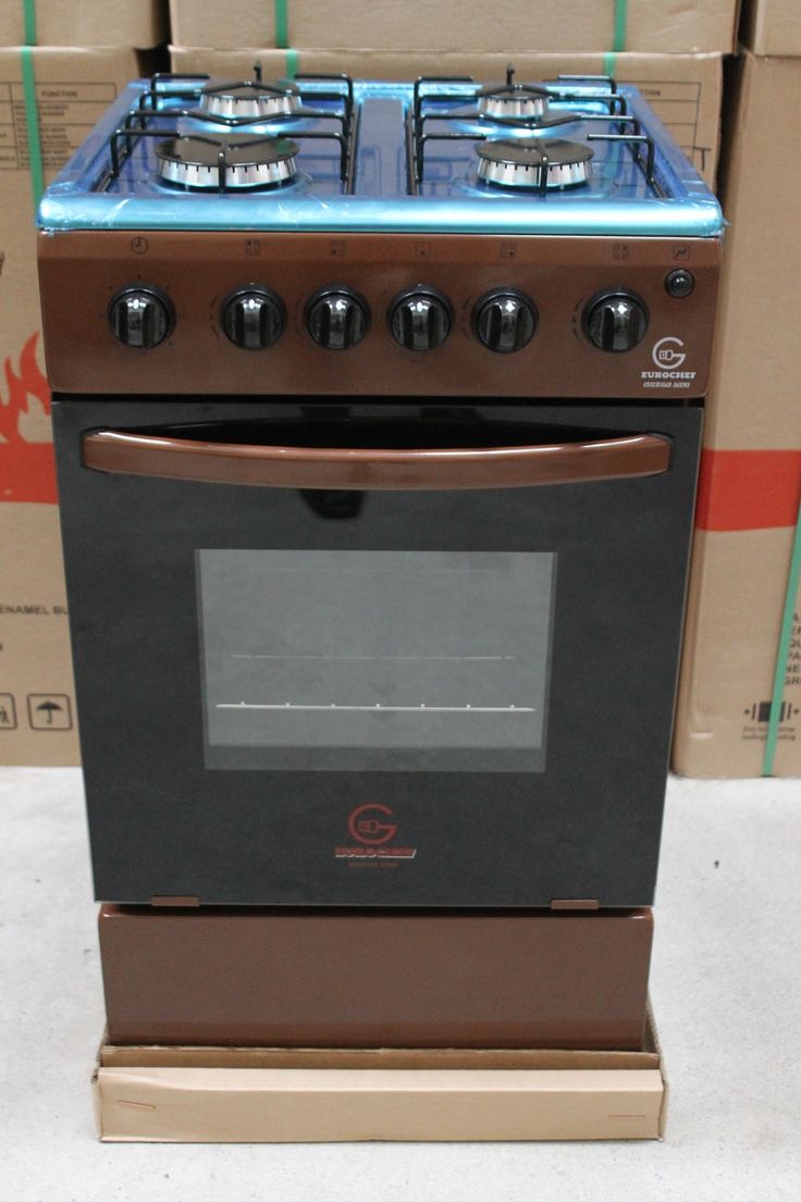 an oven with three burners and two doors in front of boxes on the floor