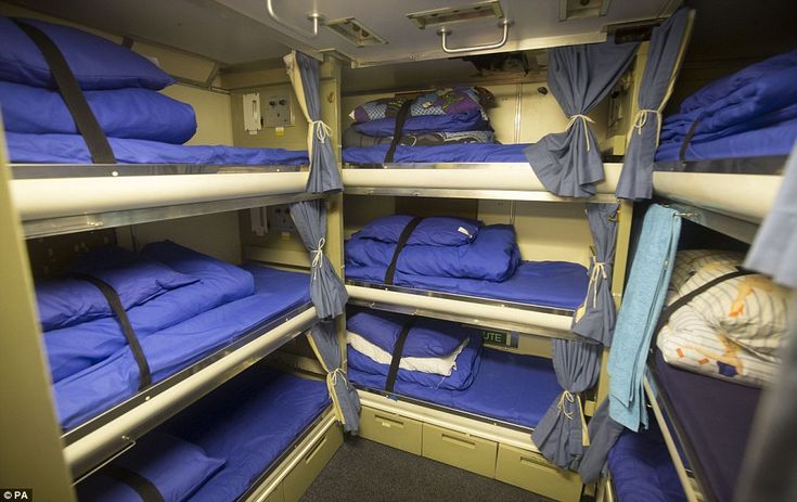 bunk beds in a room with blue sheets and blankets on the bottom bunks,