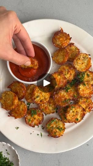 a person dipping sauce onto some food on a plate