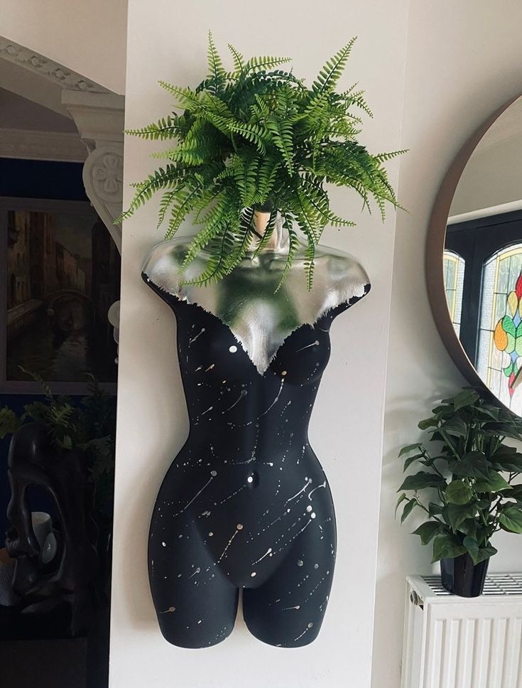 there is a potted plant in the shape of a woman's body