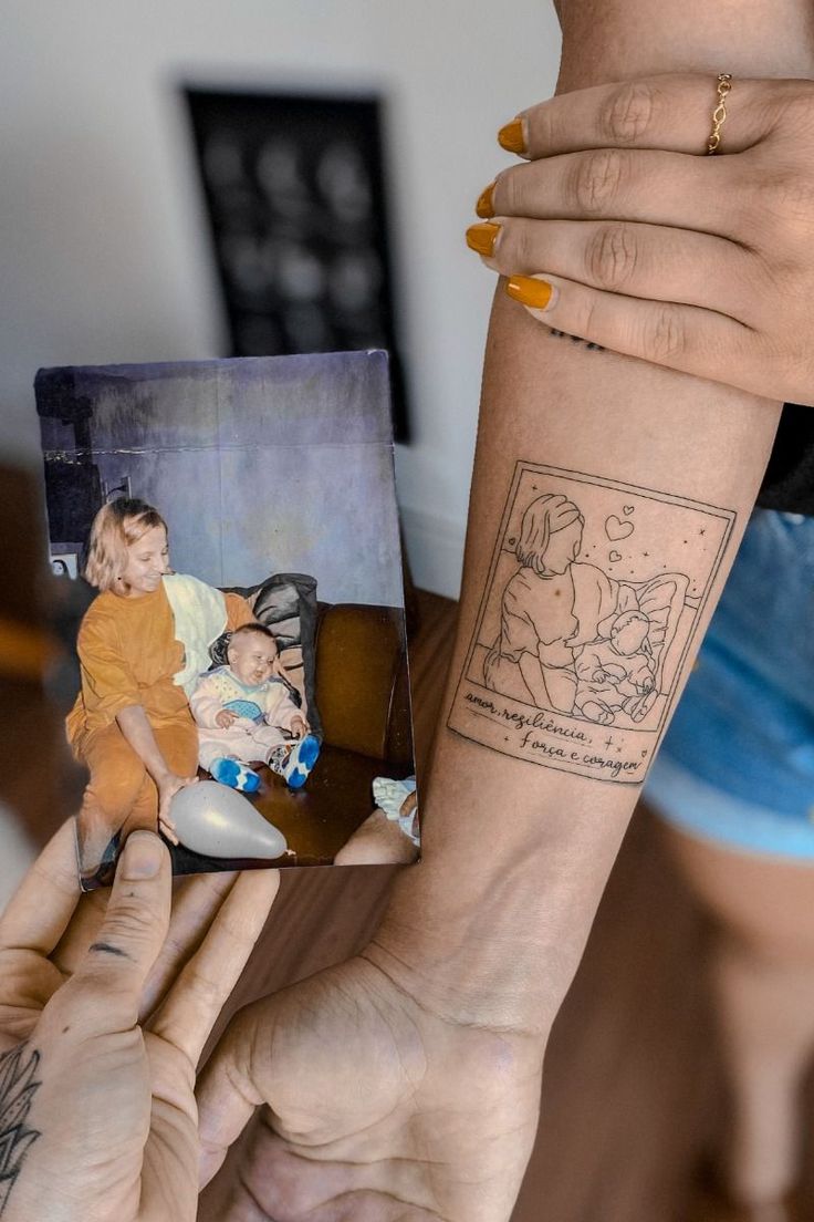 a woman holding up a small tattoo on her arm and another person's hand