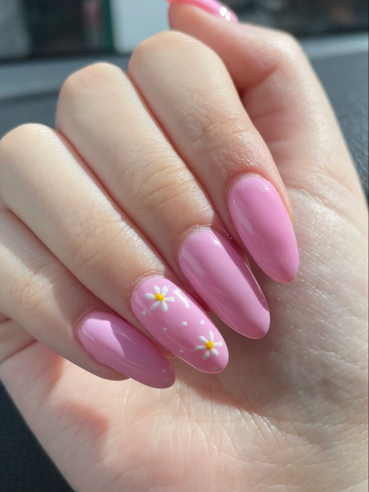 a woman's hand with pink nail polish and white flowers on the tip of her nails