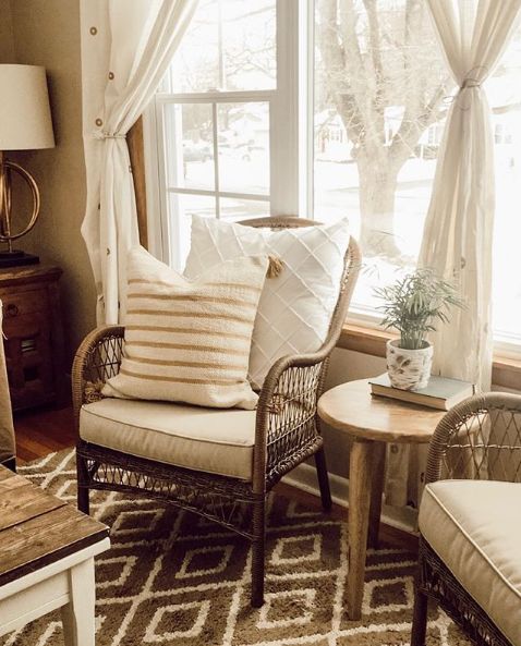 a living room filled with furniture and a large window covered in white curtained drapes