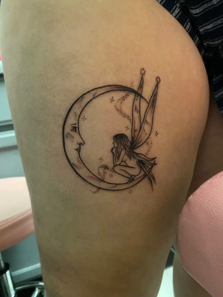 a woman's thigh with a fairy sitting on top of the moon and stars