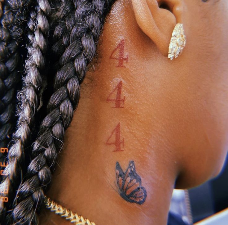 a close up of a woman's ear with butterfly tattoos on her left side