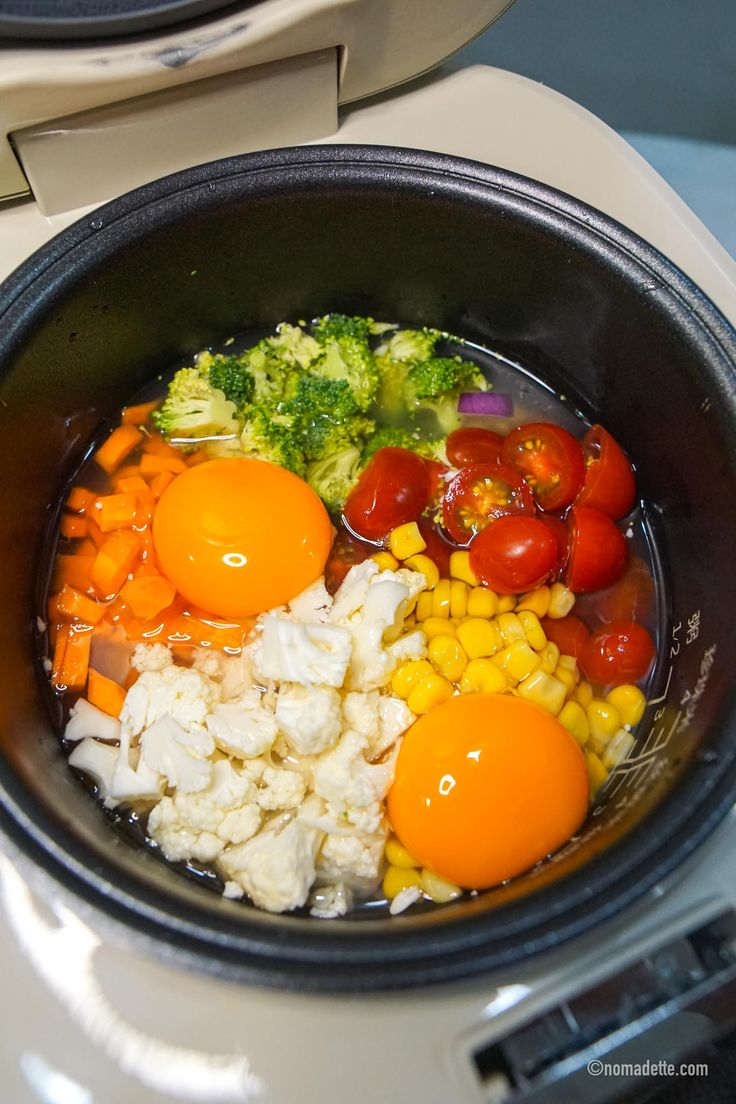 a bowl filled with vegetables and rice on top of a stove