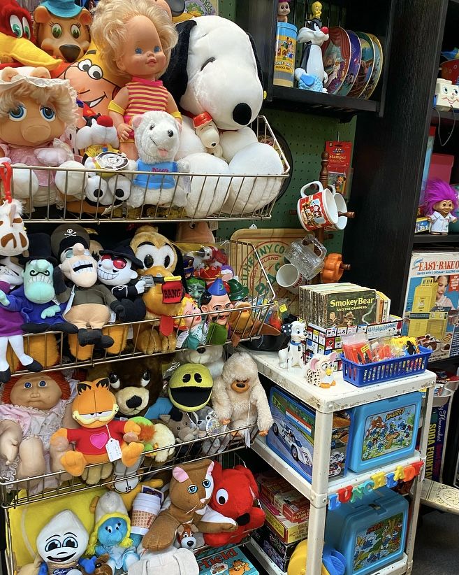 there are many stuffed animals on the shelves in this toy store, and one is for sale