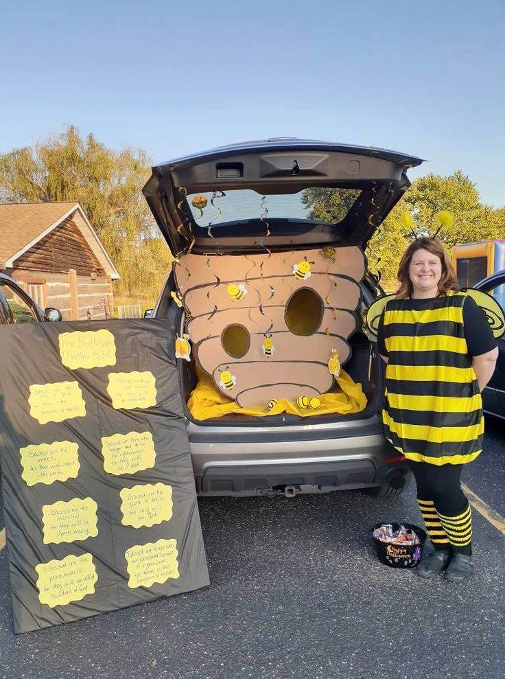 a woman standing next to the back of a car with its trunk open and bees on it