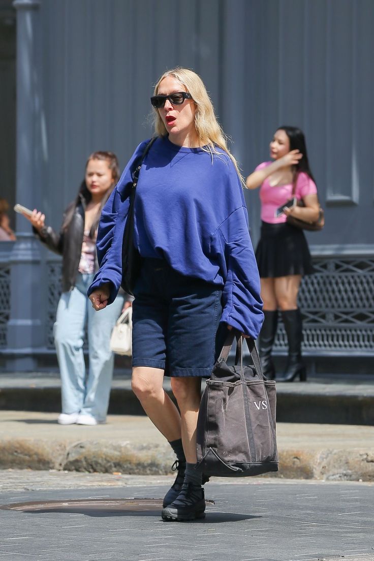 a woman walking down the street carrying a bag