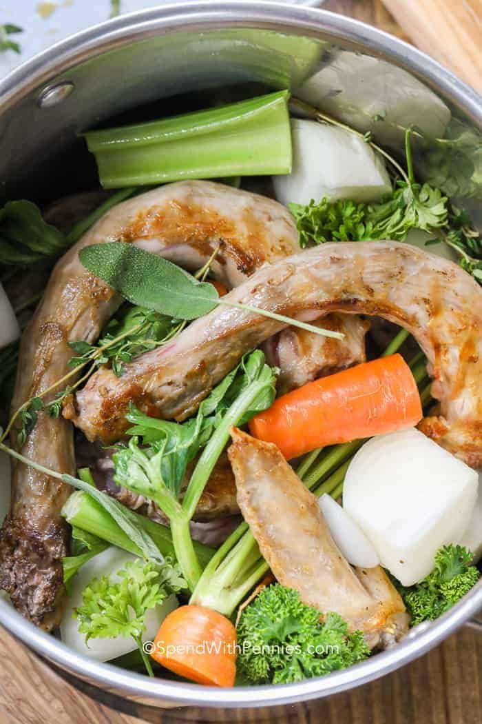 a pot filled with meat and vegetables on top of a wooden table