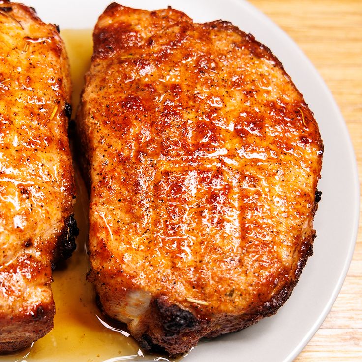 two pieces of meat sitting on top of a white plate