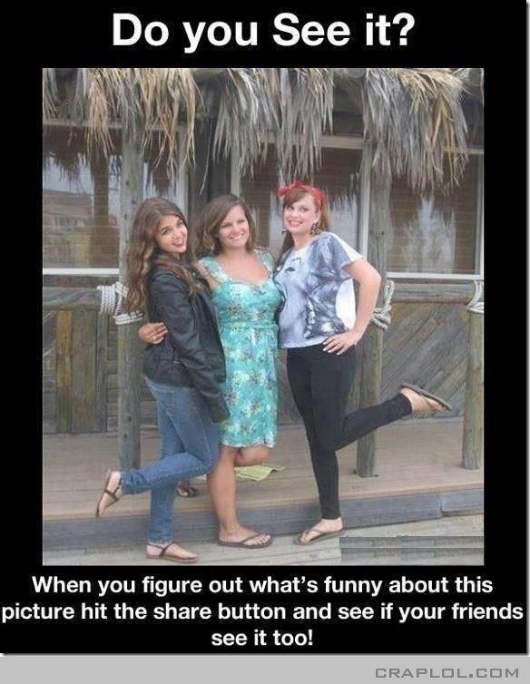 three girls posing for the camera in front of a hut