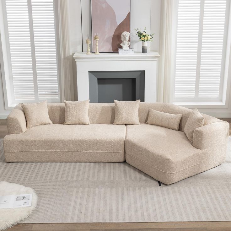 a living room with a large sectional couch and rug on the floor in front of a fireplace