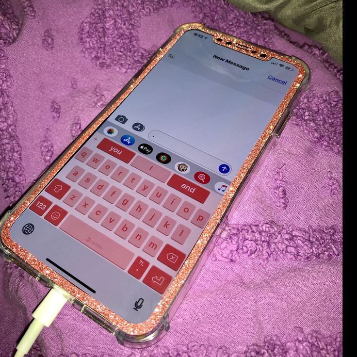 an open cell phone sitting on top of a purple blanket