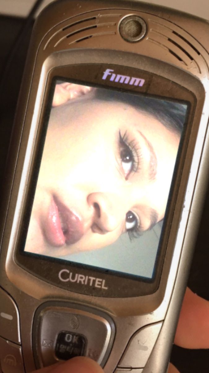 a close up of a cell phone with a woman's face on the screen