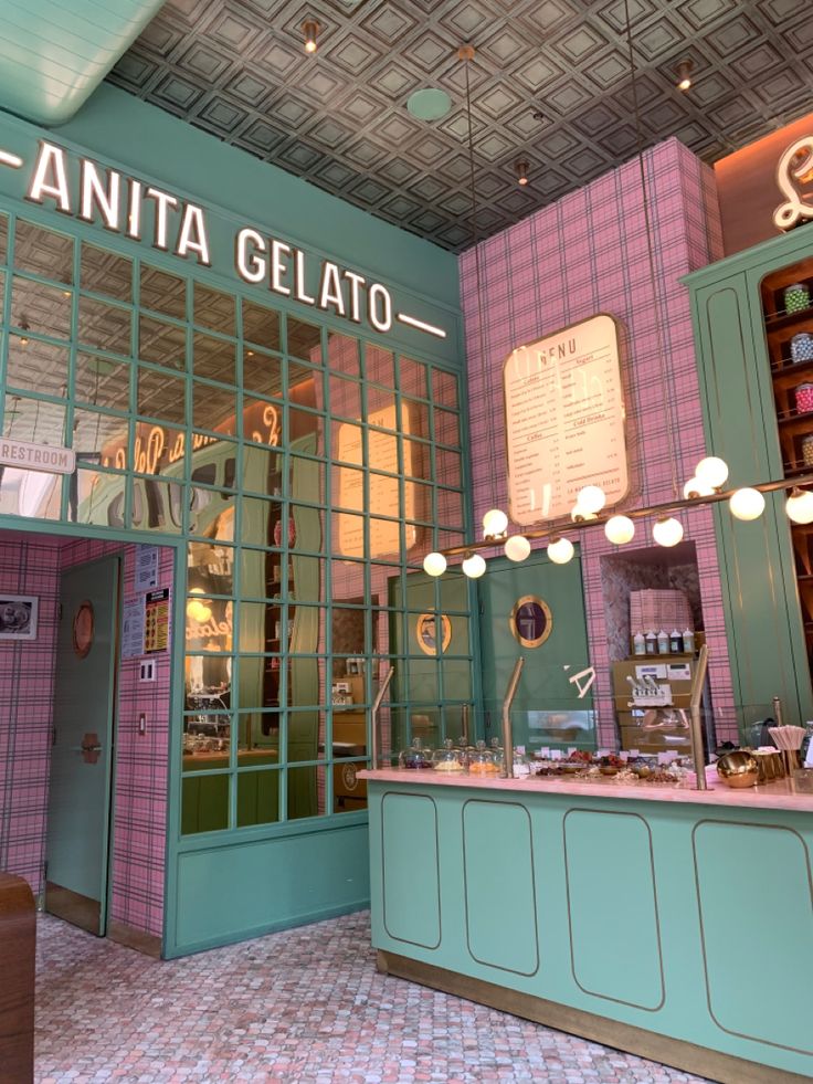 the interior of an italian gelato shop with pink and blue walls, green doors, and checkered tile flooring