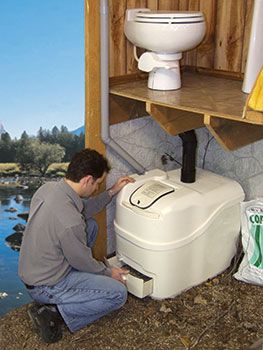 a man kneeling down next to a white toilet