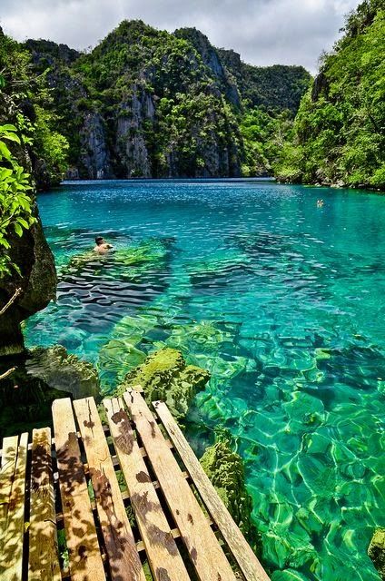 the water is crystal blue and there are people swimming in it