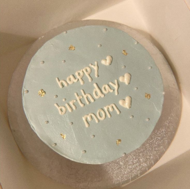 a birthday cake with white frosting and gold stars on it's side, sitting in a box