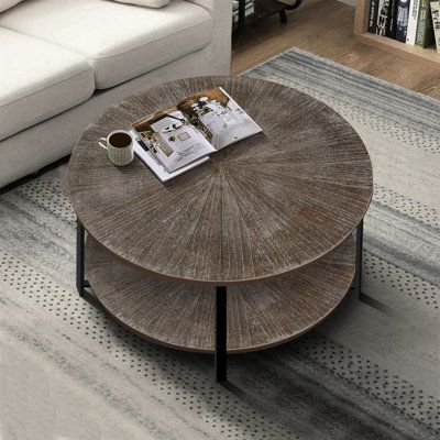 a coffee table sitting on top of a rug in front of a couch and book shelf