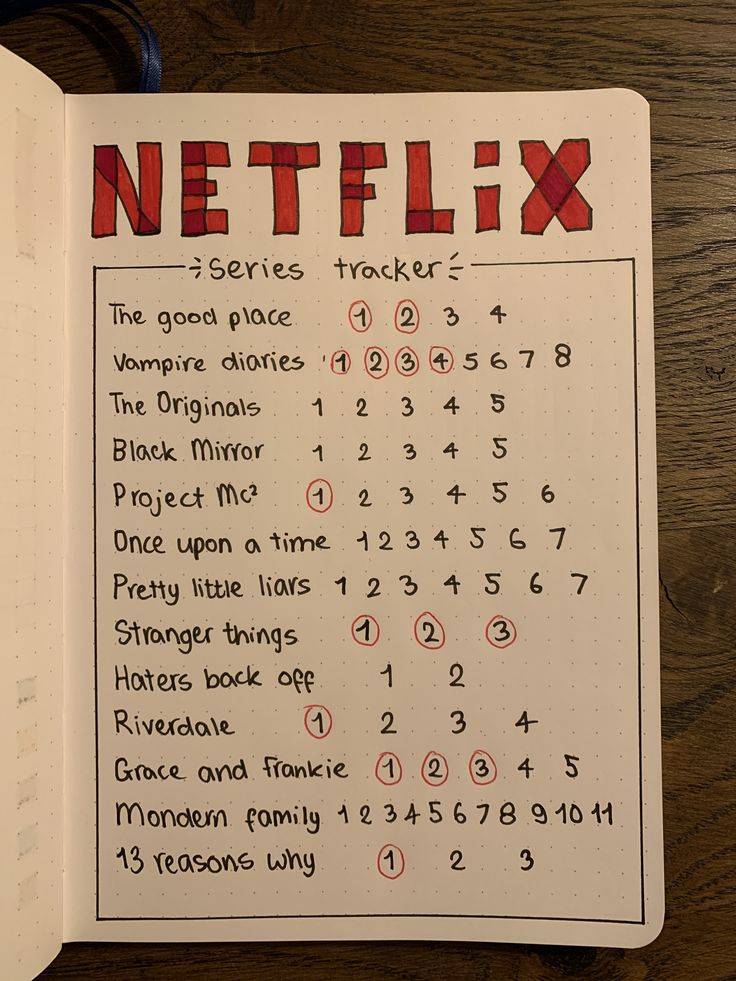 a notebook with the words netflix written in red and black on it, sitting on a wooden table