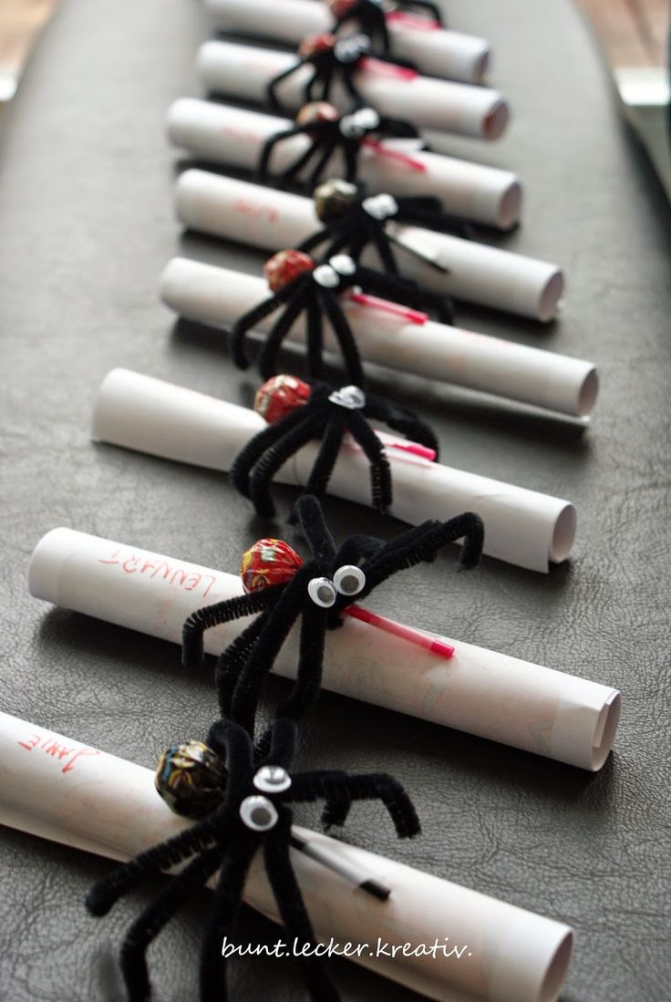 a row of white and black graduation caps with red writing on them, tied together