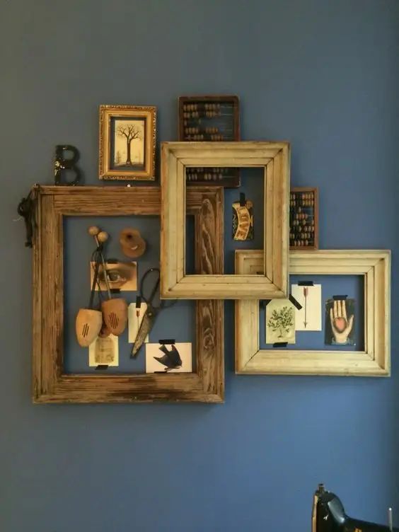 three wooden frames are hanging on the wall above a sewing machine and an old fashioned sewing needle