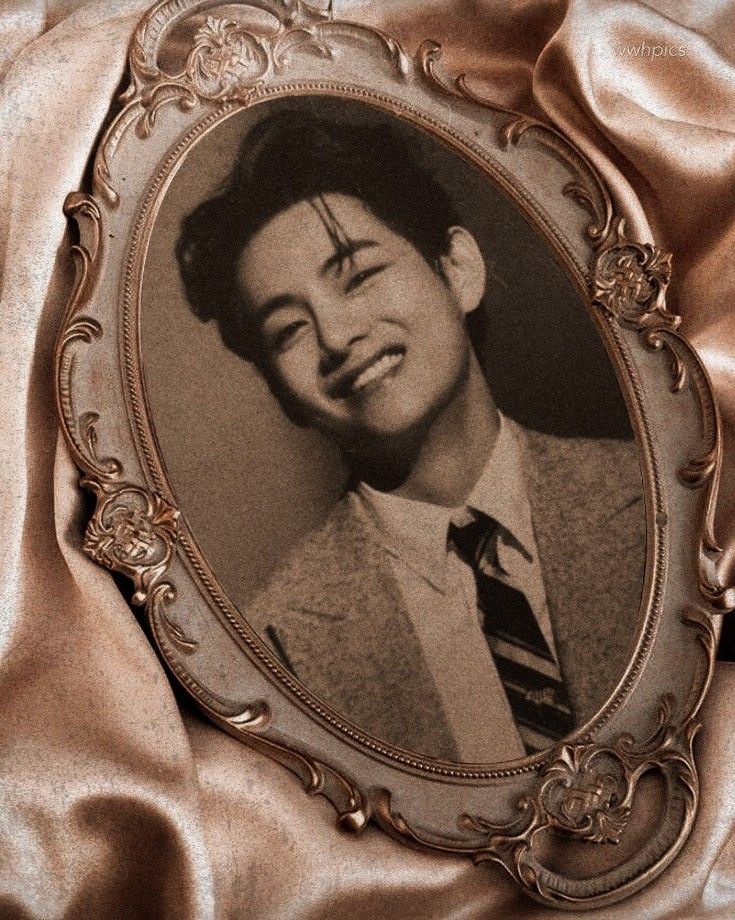 an old photo of a man in a suit and tie with his eyes closed on a gold satin background