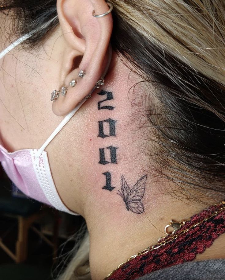 a woman with a tattoo on her neck and behind the ear that reads, she is in hebrew