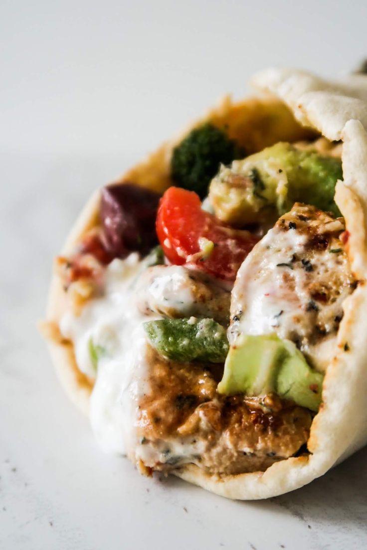 a pita filled with meat, veggies and sauce