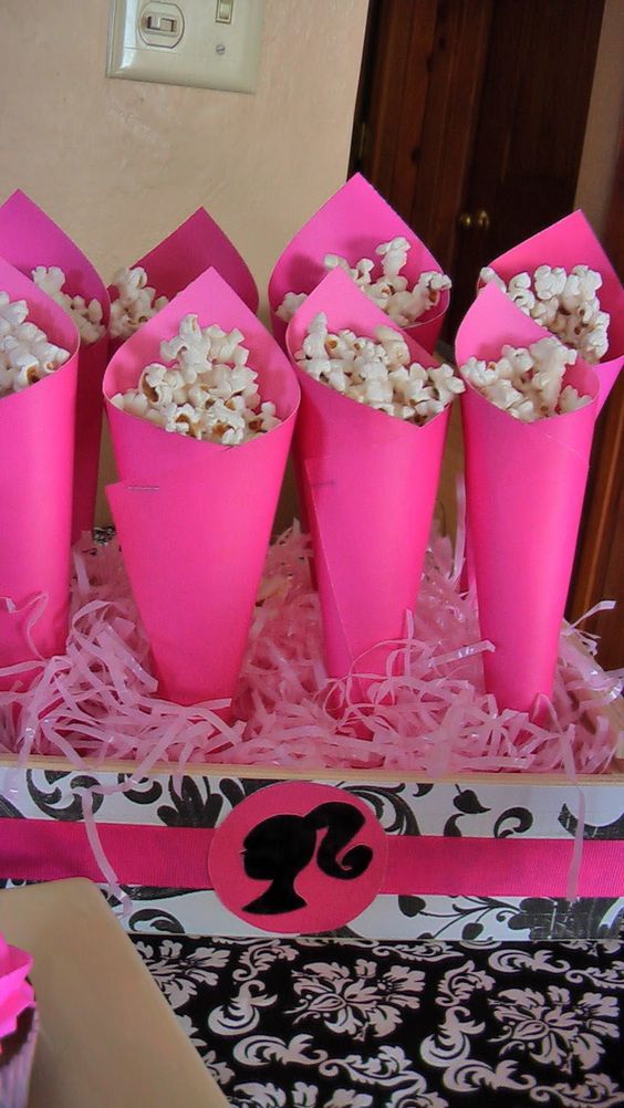 pink cupcakes with white chocolate sprinkles are in the middle of a box