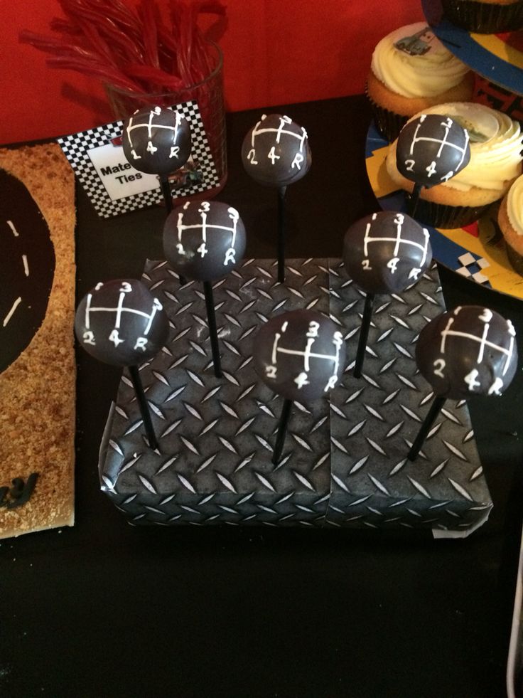 a table topped with cupcakes covered in black frosting and decorated with crosses