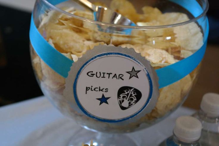 a glass filled with lots of food sitting on top of a white cloth covered table