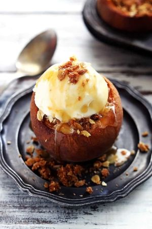 two desserts on black plates with spoons next to them