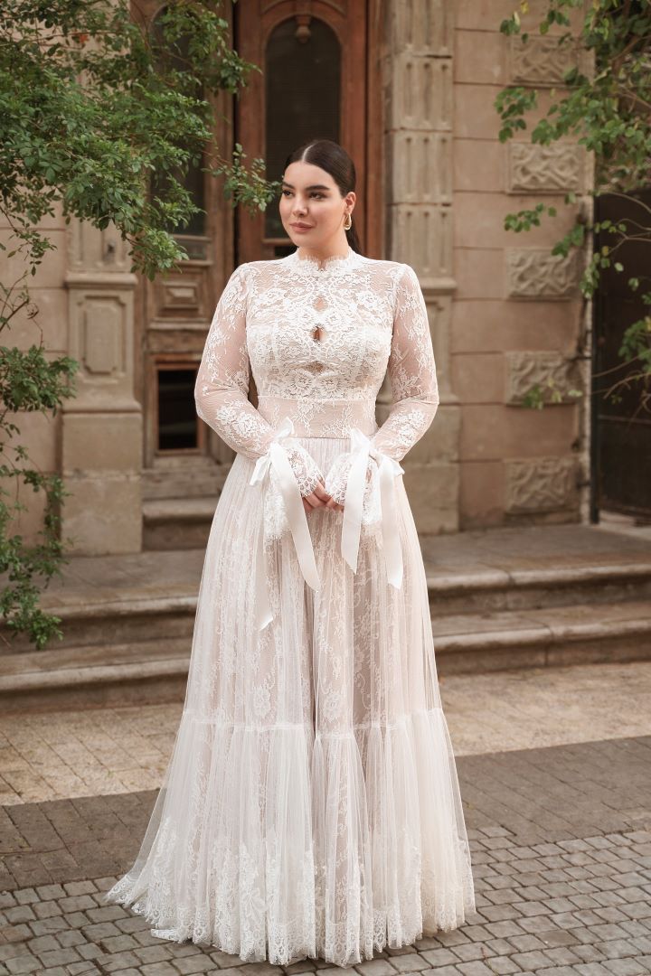 a woman in a white dress standing outside